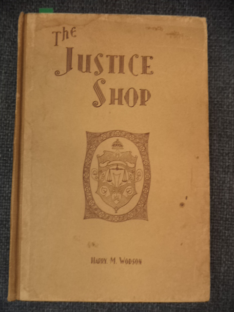 Image for The Justice Shop. "If all the mothers' tears shed in a police court could be gathered up, they would make a river which would reach to the seas of Eternity."